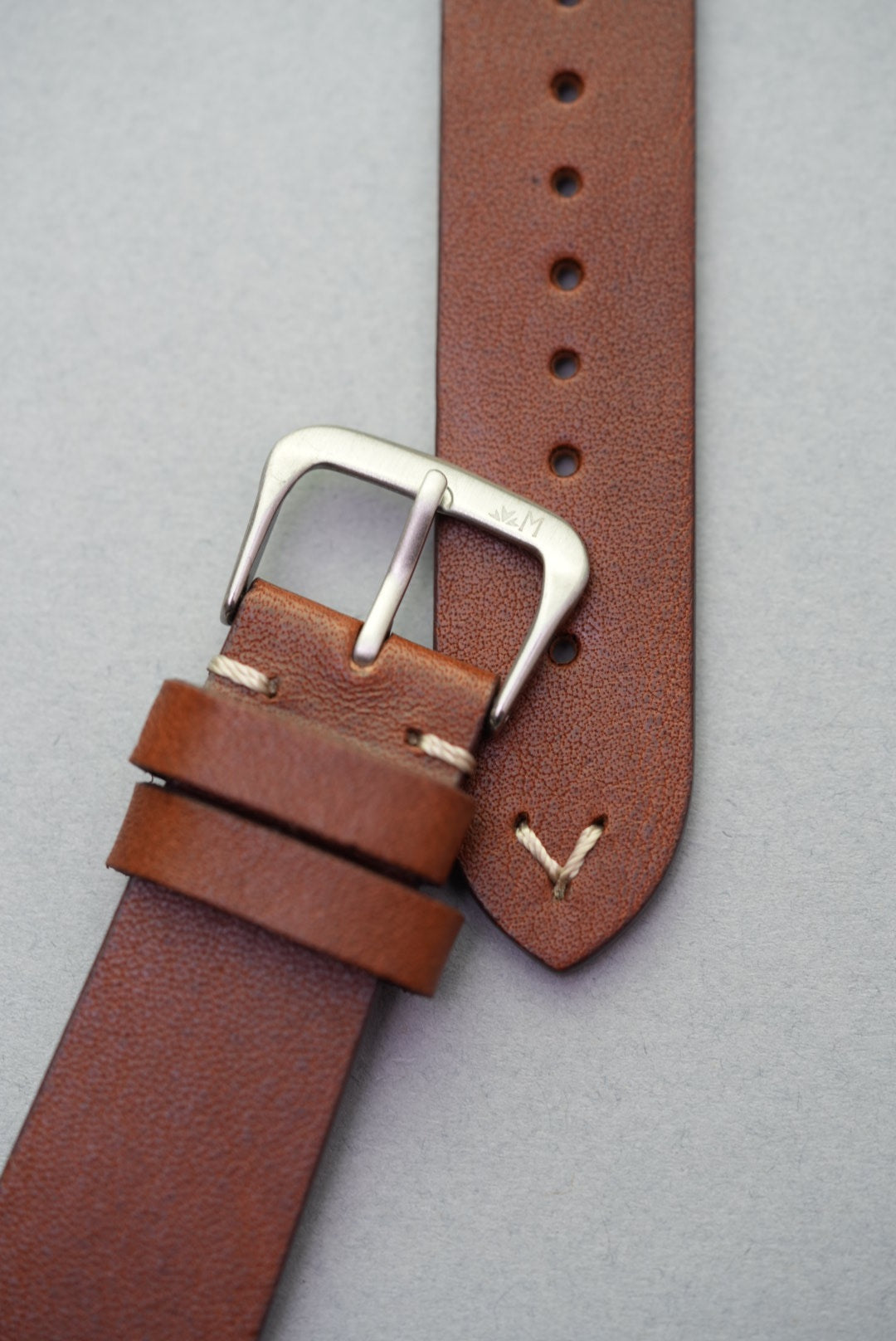 Brown calfskin strap close-up view of lug-stitched leather and buckle