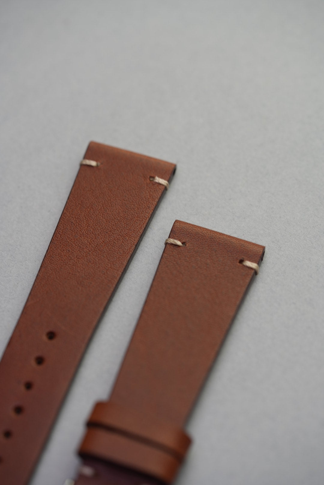 Tip of brown calfskin strap showing stitch detail for Apple Watch or classic watch