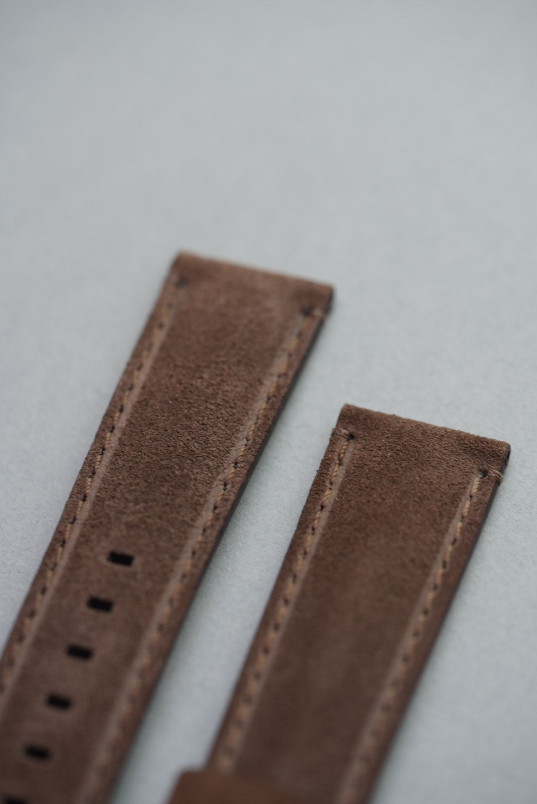 Macro detail of suede texture and stitching on brown leather watch strap for replacement