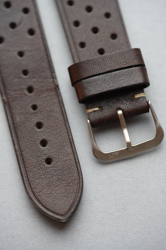 Top view of perforated hole pattern on dark brown leather watch strap