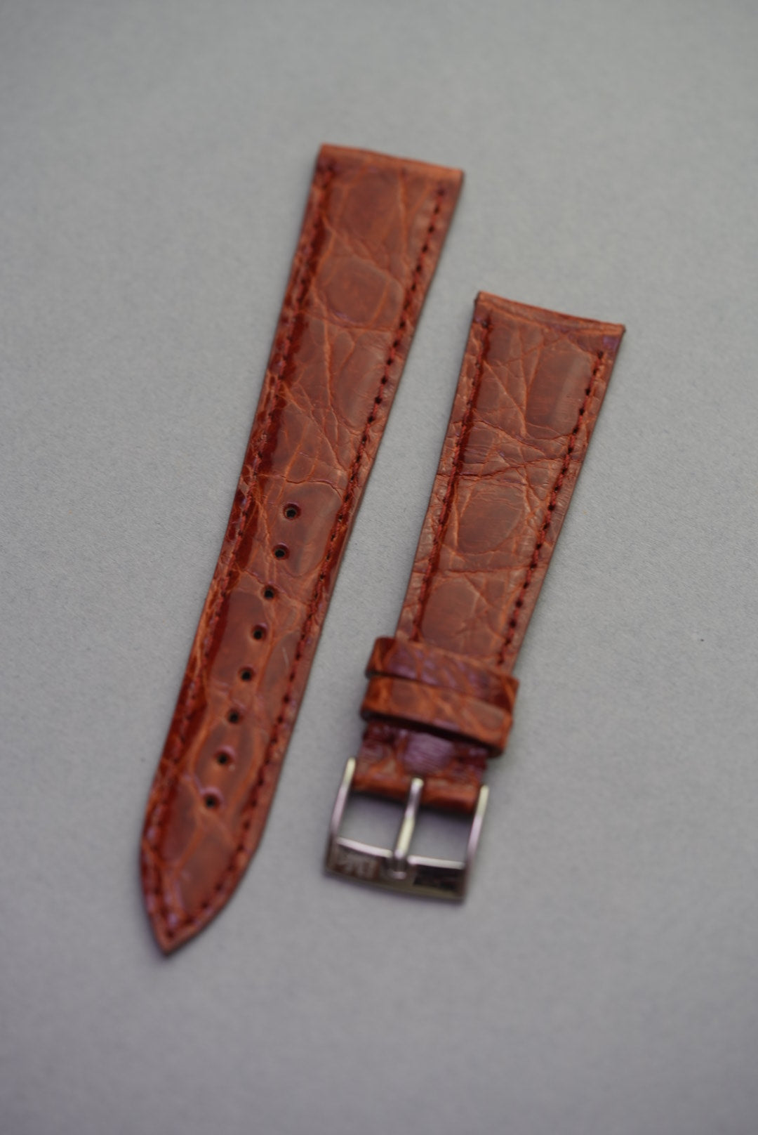 Full view of the caramel crocodile strap for Cartier, with a semi-gloss finish, natural scale texture, and polished buckle.