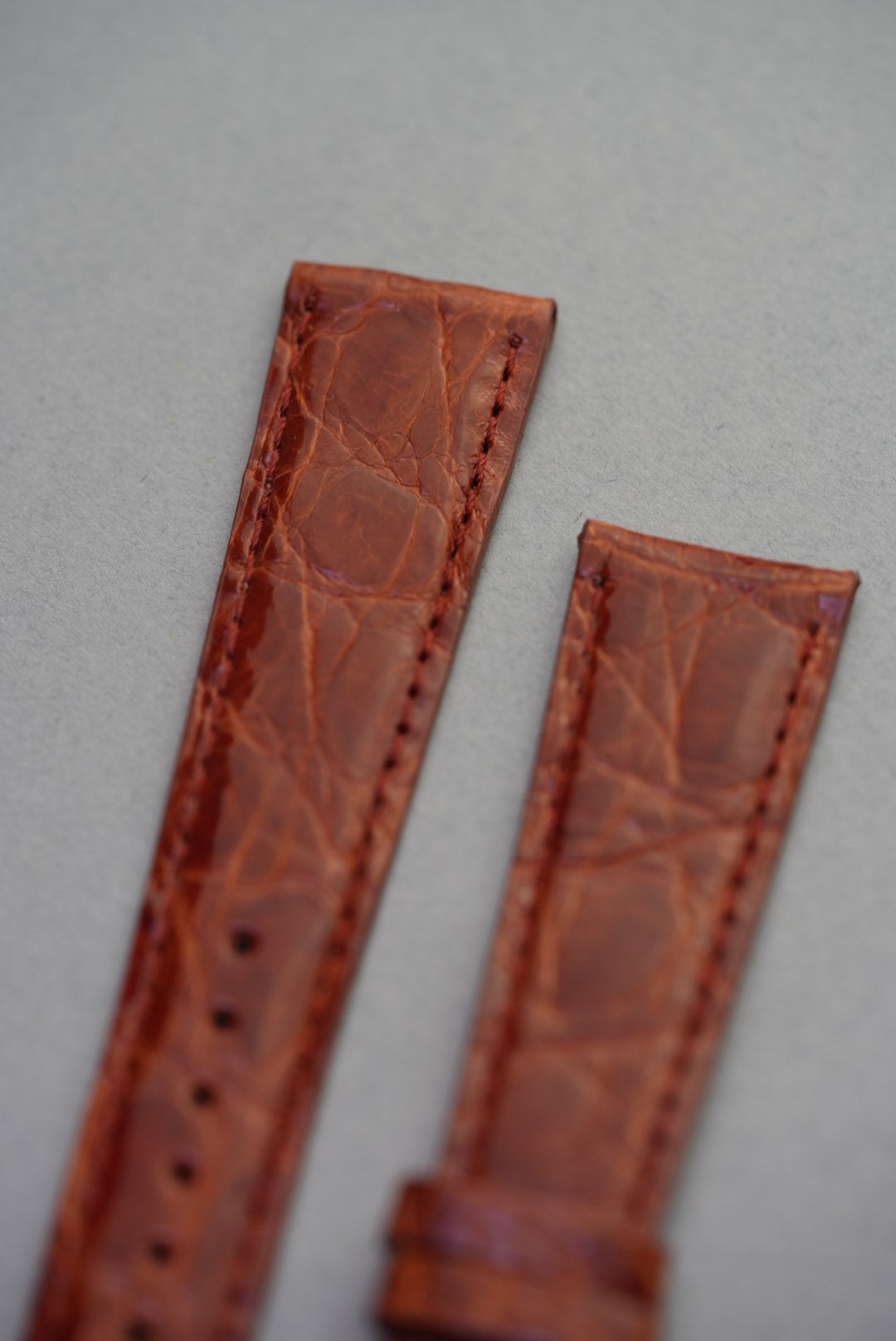 Close-up view of the upper section of the caramel crocodile leather strap, showcasing fine grain and warm amber tones.