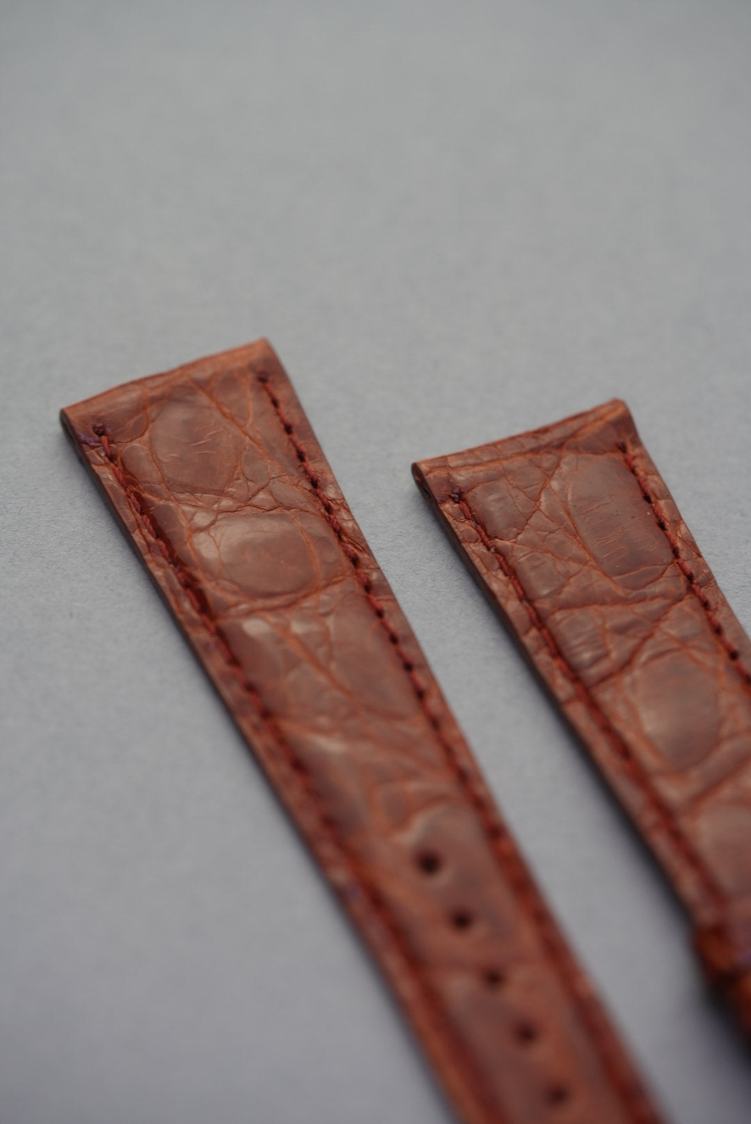 Close-up view of the upper section of the caramel crocodile leather strap, showcasing fine grain and warm amber tones.