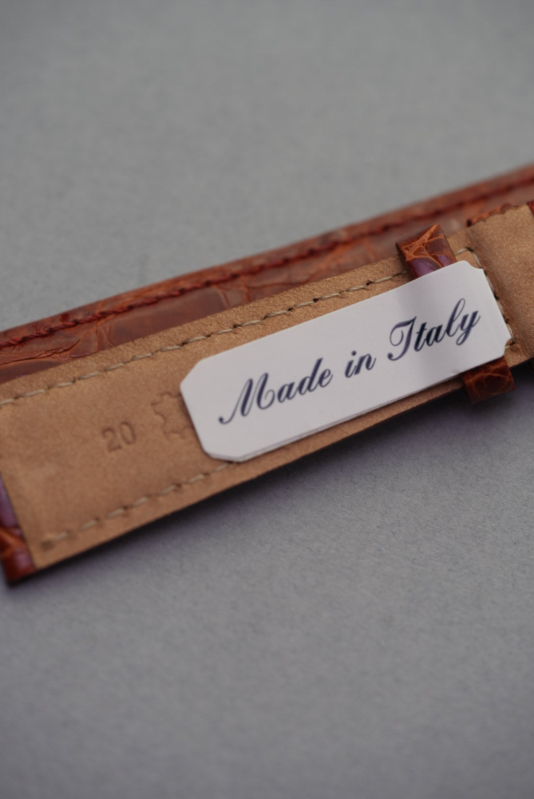 Underside of caramel crocodile leather watch strap for Cartier, featuring 20mm lug width marking and soft tan lining.