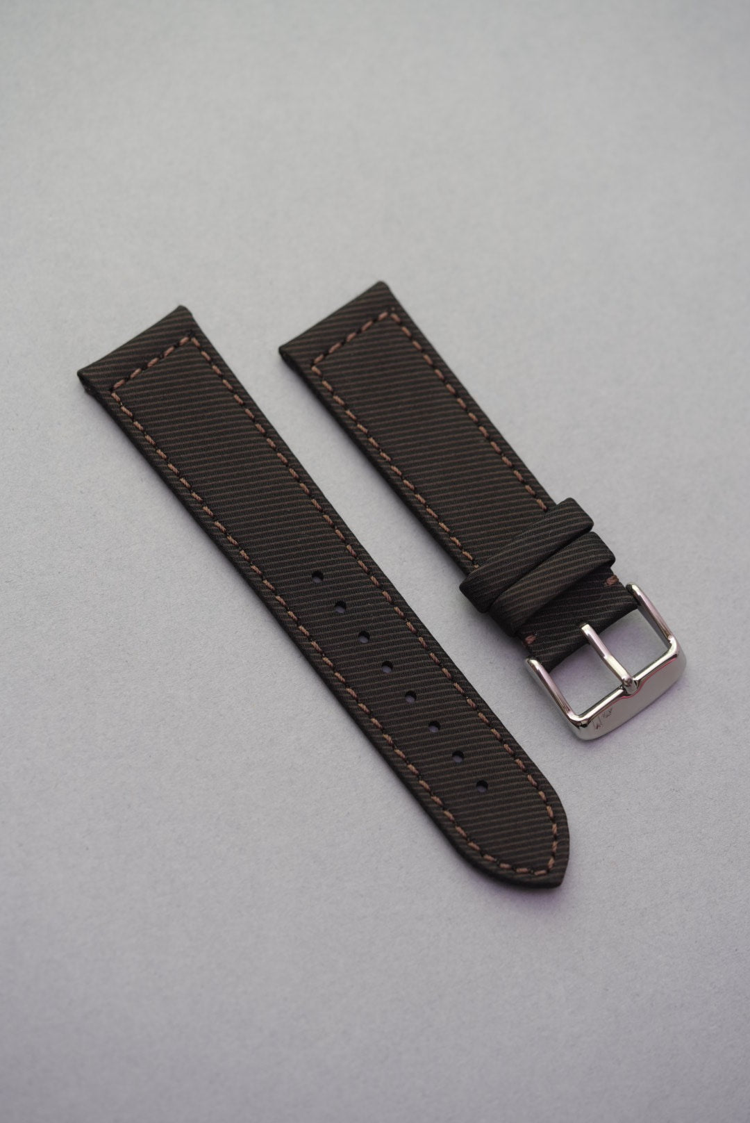 Textured clay brown recycled watch strap with matching brown stitching and brushed buckle, crafted from gabardine for a structured finish.
