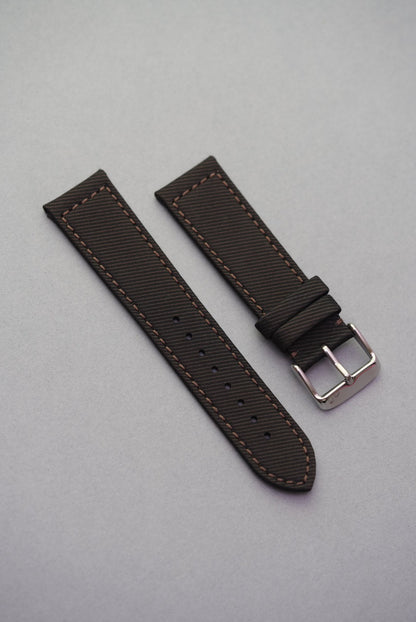 Textured clay brown recycled watch strap with matching brown stitching and brushed buckle, crafted from gabardine for a structured finish.