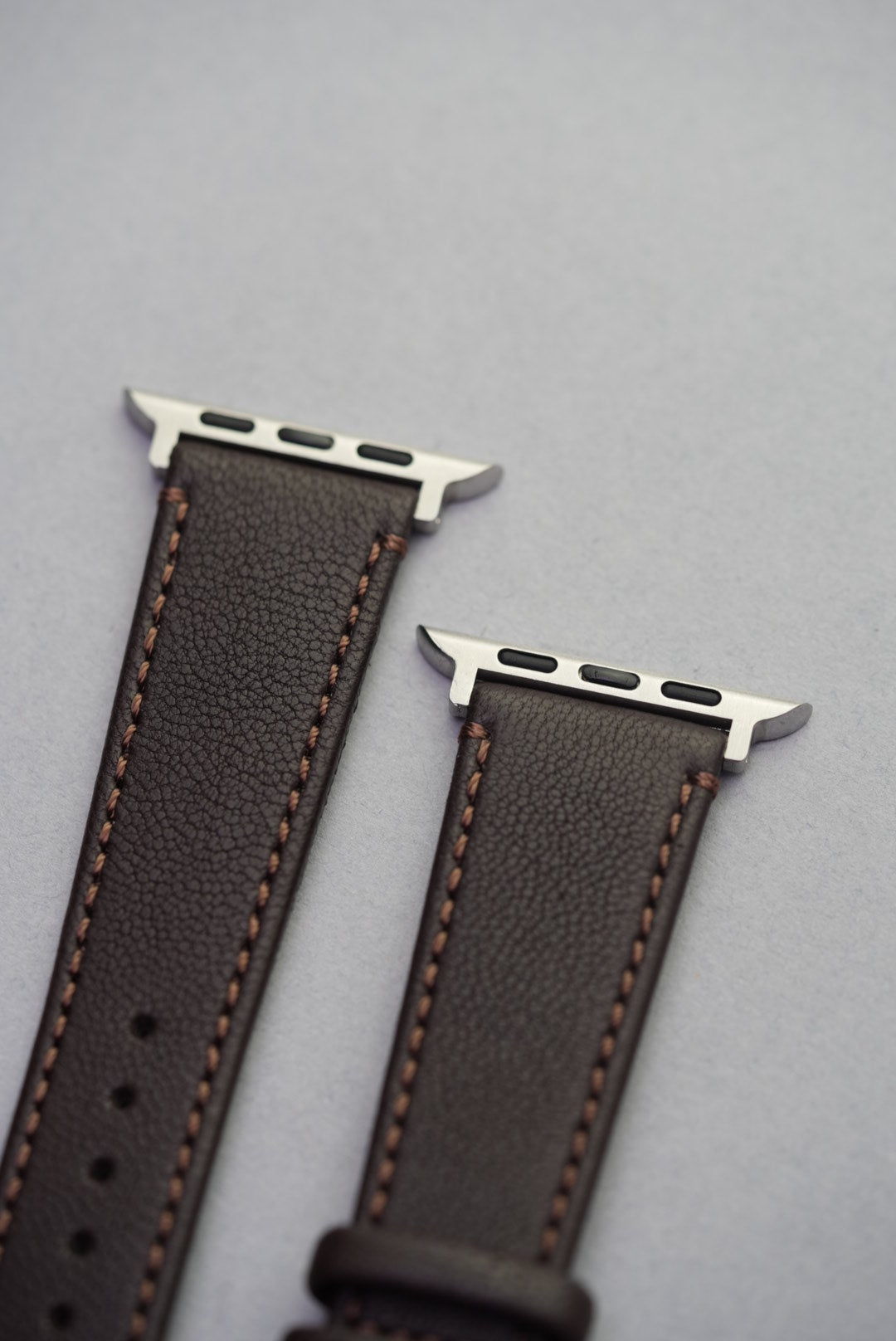 Adapter close-up of the Cortado Chestnut strap for Apple Watch, showing soft brown sheepskin and contrast stitching.