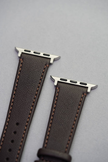 Adapter close-up of the Cortado Chestnut strap for Apple Watch, showing soft brown sheepskin and contrast stitching.