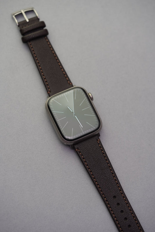 Full-length view of the Cortado Chestnut strap paired with Apple Watch, featuring deep brown grain and mocha stitching.