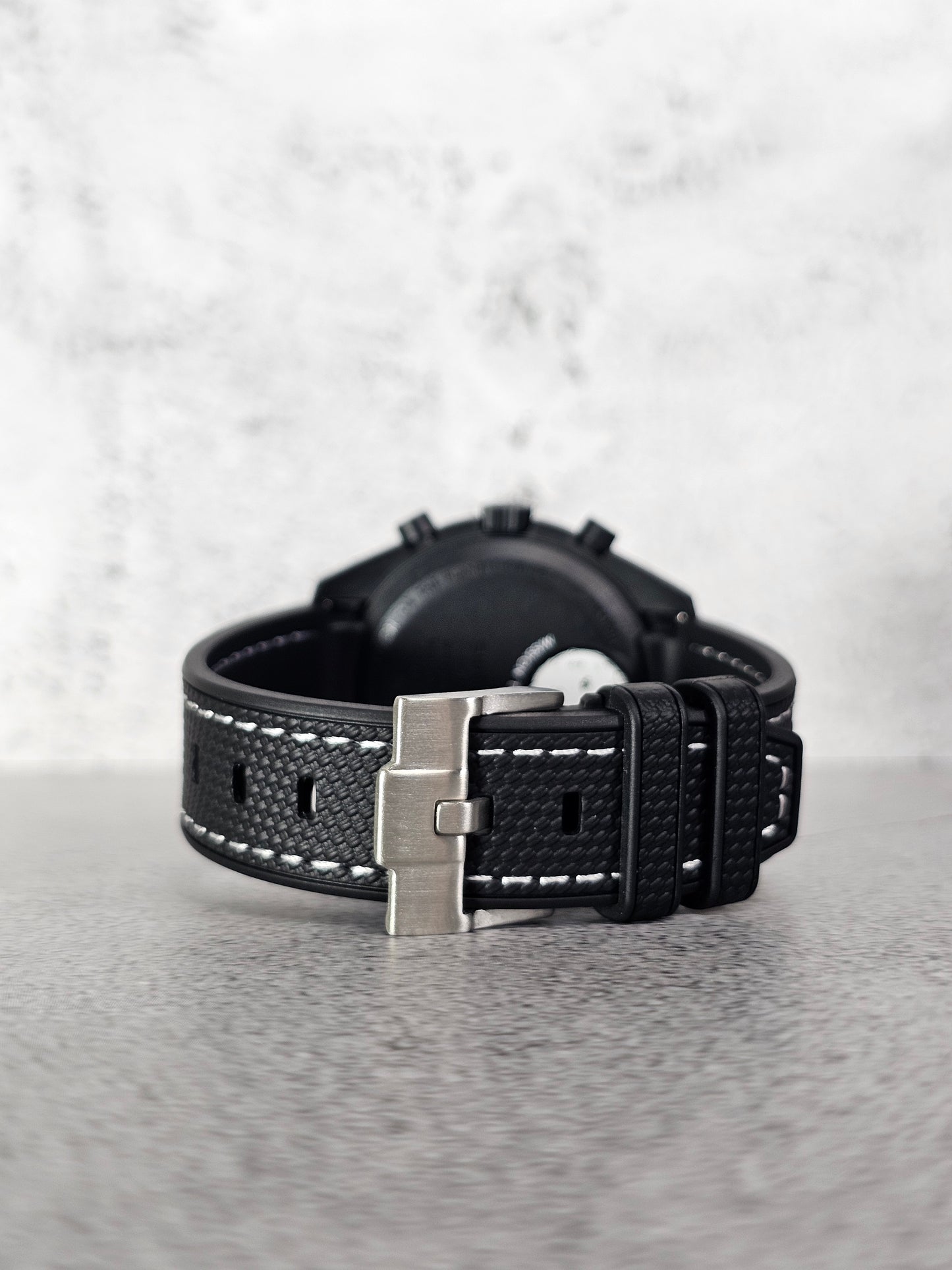 Curved-end black rubber strap showing seamless case fit on Omega x Swatch MoonSwatch Snoopy.