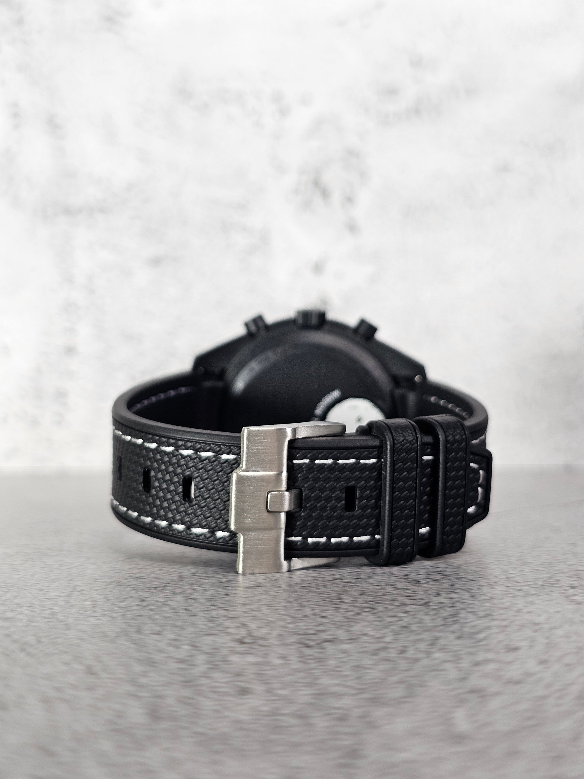 Curved-end black rubber strap showing seamless case fit on Omega x Swatch MoonSwatch Snoopy.