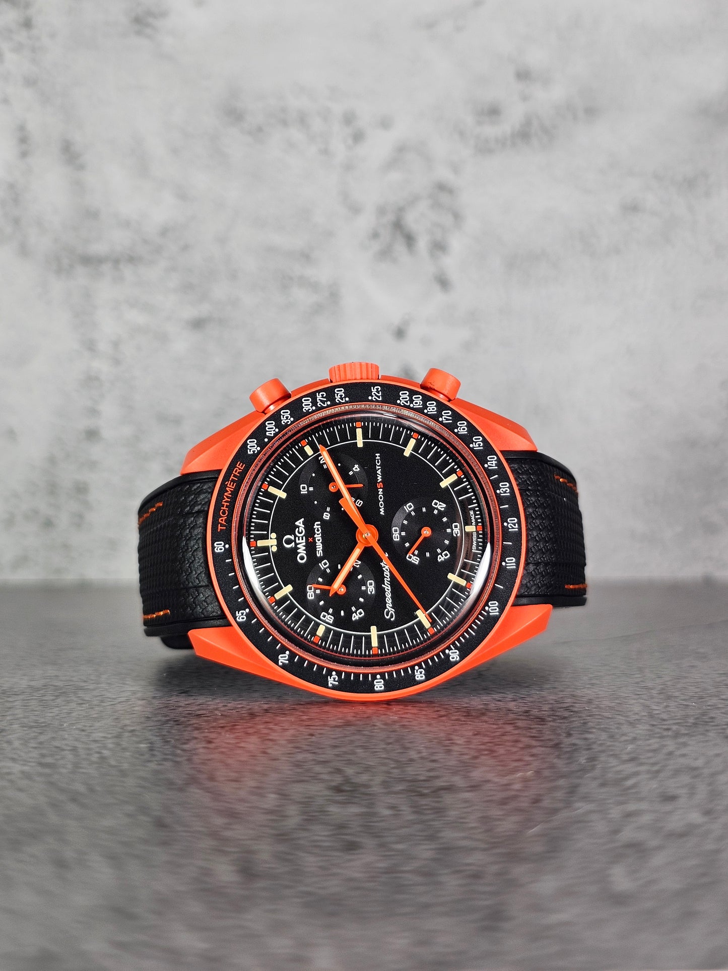 Curved-end black and lava rubber strap showing seamless case fit on Omega x Swatch MoonSwatch Mission on Earth Lava.