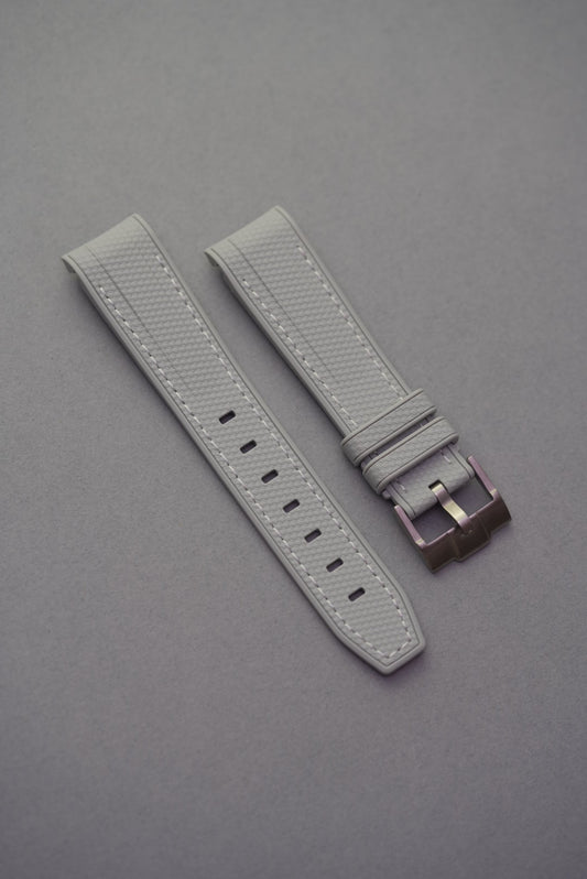 Light grey MoonSwatch strap in rubber woven texture with curved ends and subtle white stitching