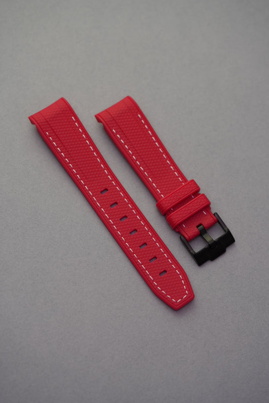 Red curved rubber woven strap with white stitching and black buckle, designed for a snug MoonSwatch fit.