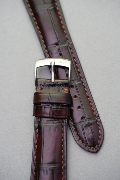  Close-up of the dark brown alligator-style grain and double loop keepers on calfskin watch strap.