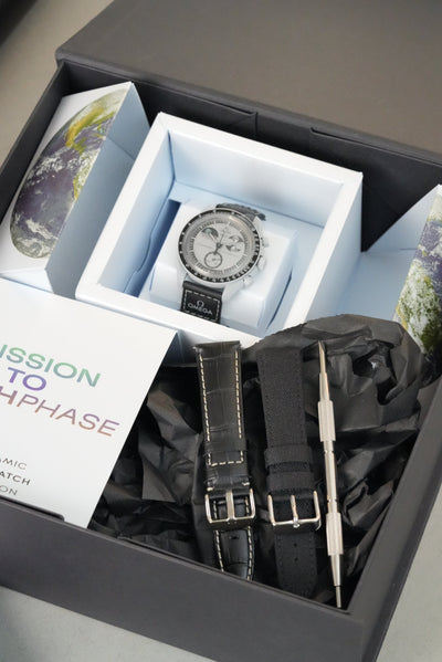 Watch set with a watch, strap, and packaging in an open box.