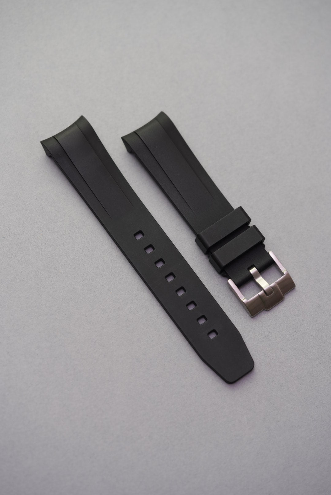 Black FKM curved rubber strap, brushed steel buckle, close-up