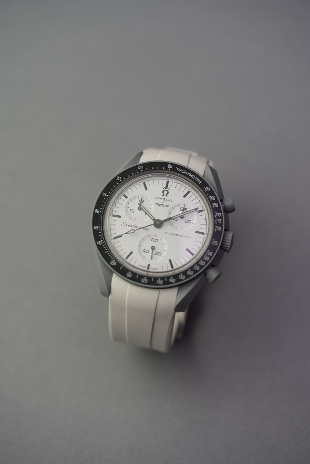 Front view of Omega x Swatch MoonSwatch with white FKM curved rubber strap, showcasing the clean Speedmaster-style dial layout.