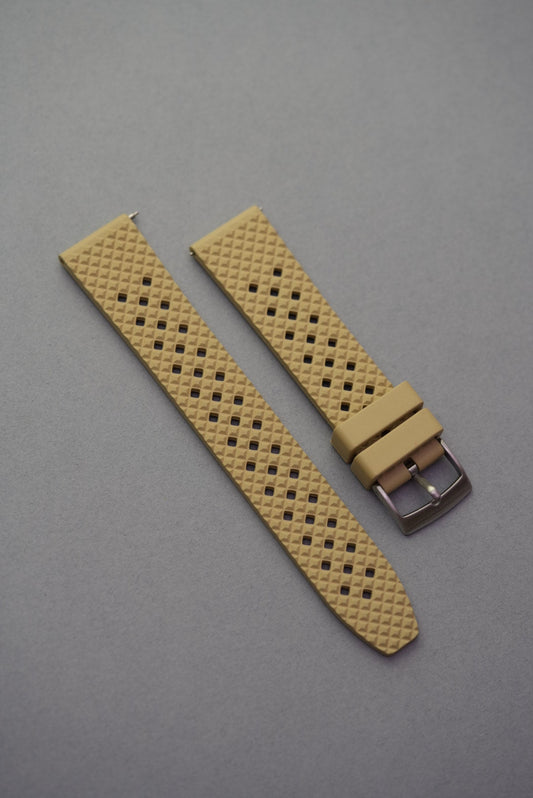 beige FKM rubber honeycomb-pattern watch strap with silver buckle, placed on a neutral grey surface.