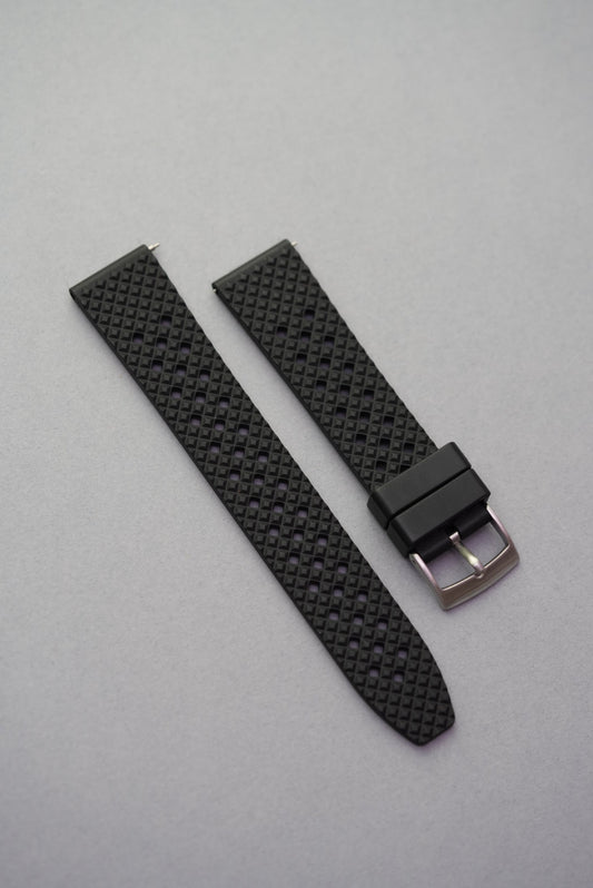  Black FKM rubber honeycomb-pattern watch strap with silver buckle, laid flat on a grey background.