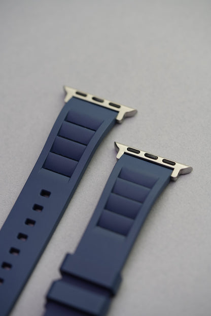 Close-up of Apple Watch lugs on navy FKM strap, highlighting quick-fit adapter ends.