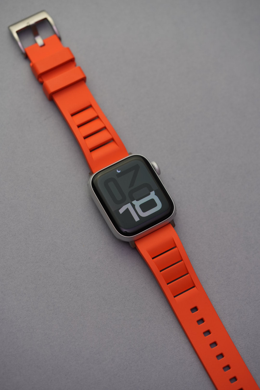 Orange FKM vented rubber strap shown fitted to an Apple Watch, laid flat and fully visible.