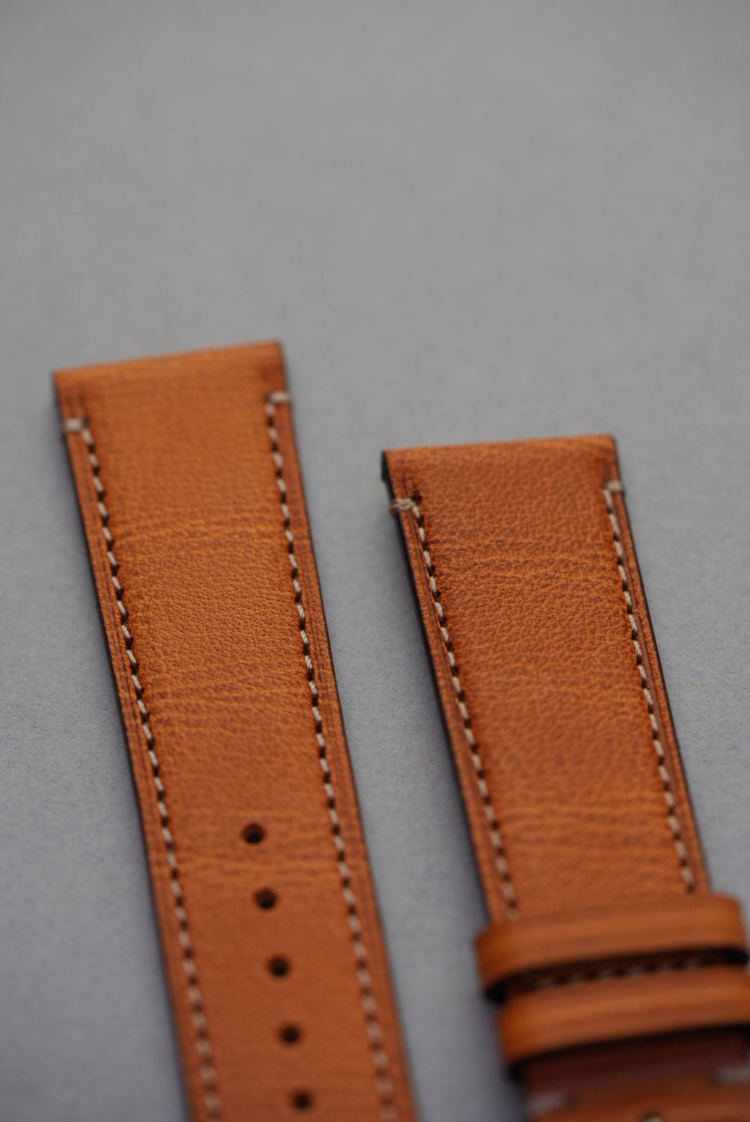 Detailed view of golden brown leather watch strap showing grain texture and stitching