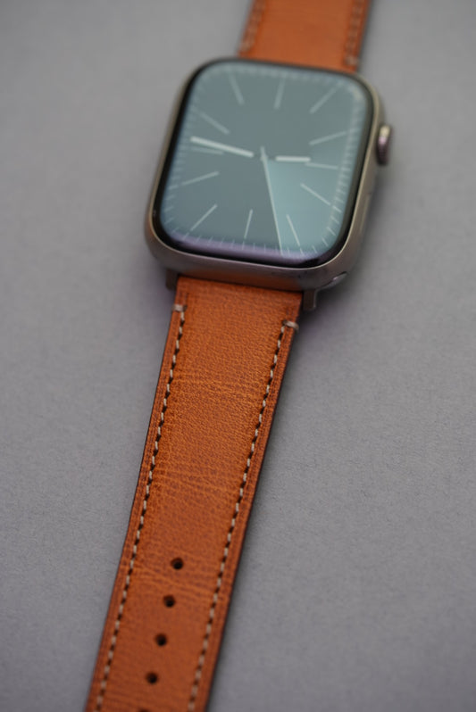 Close-up of golden brown fine grain calfskin strap fitted to Apple Watch