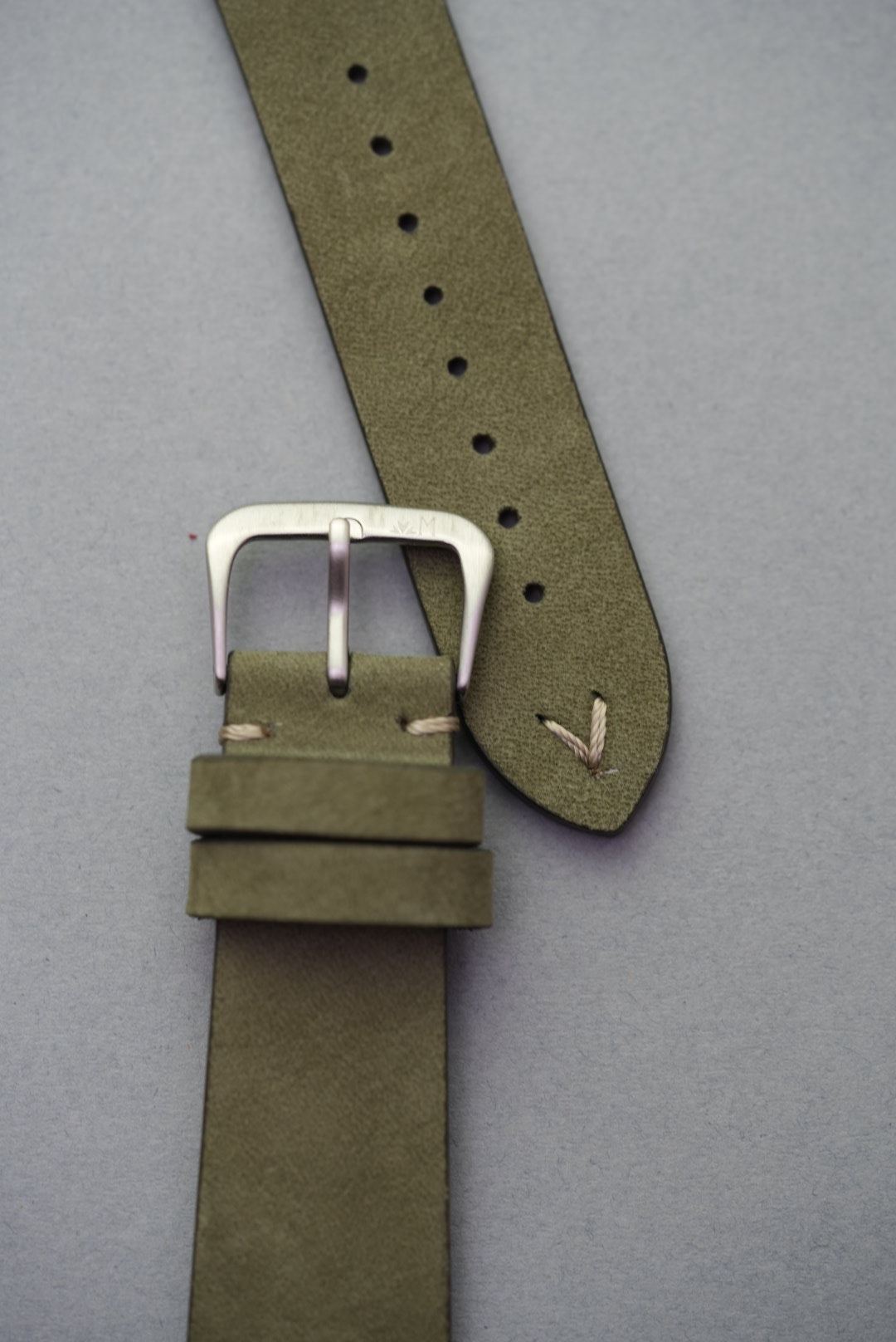 Close-up of green leather watch strap with hand-stitched lug, ideal for replacing classic straps