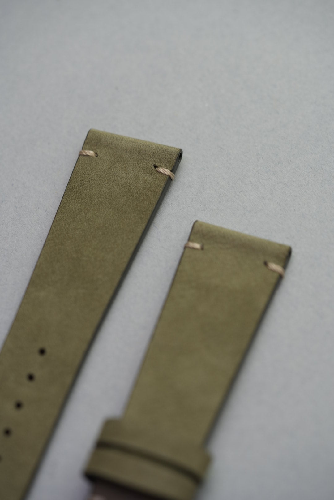 Close-up of green leather watch strap with hand-stitched lug, ideal for replacing classic straps