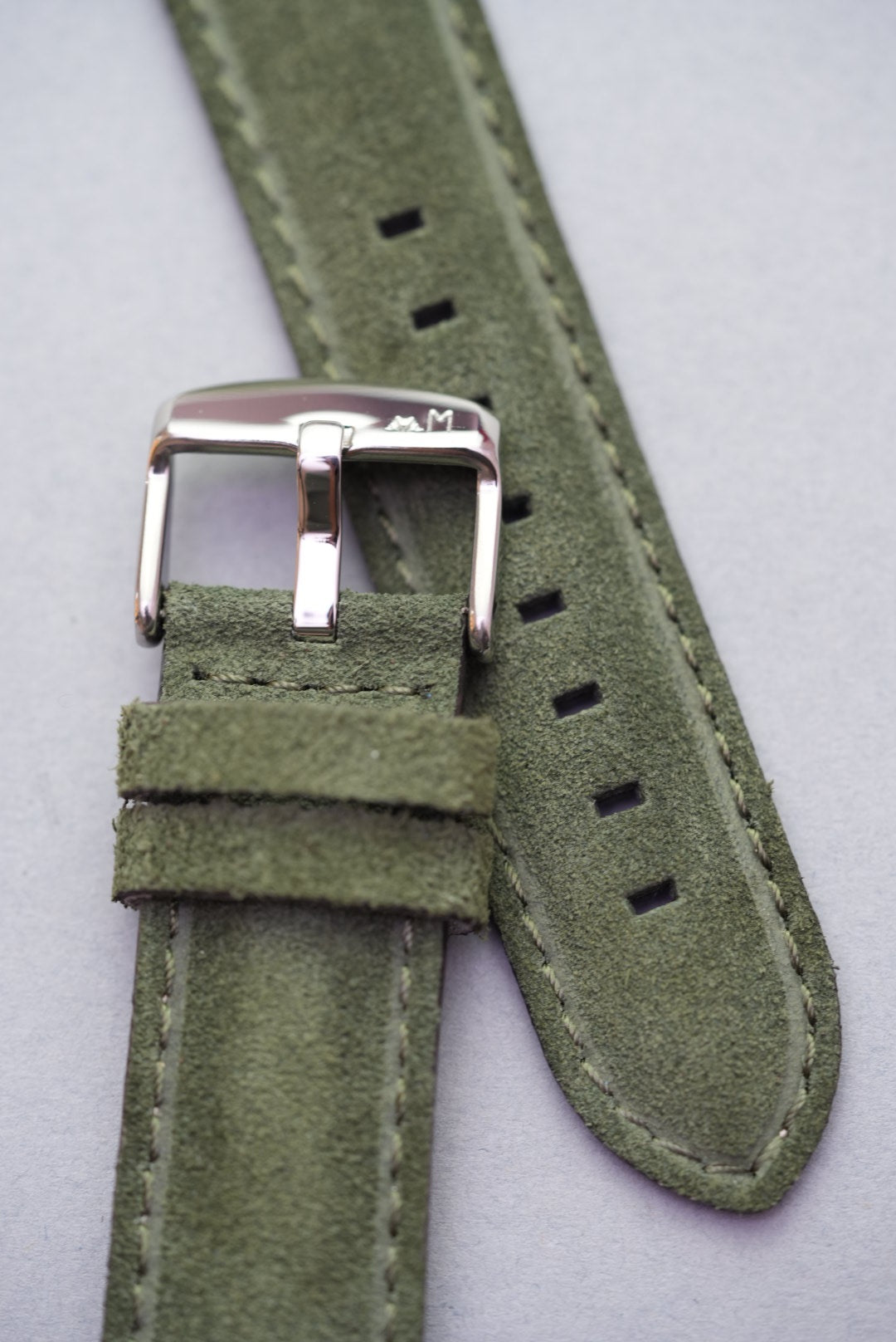 Close-up of green suede leather watch strap with stainless buckle – ideal for strap replacement