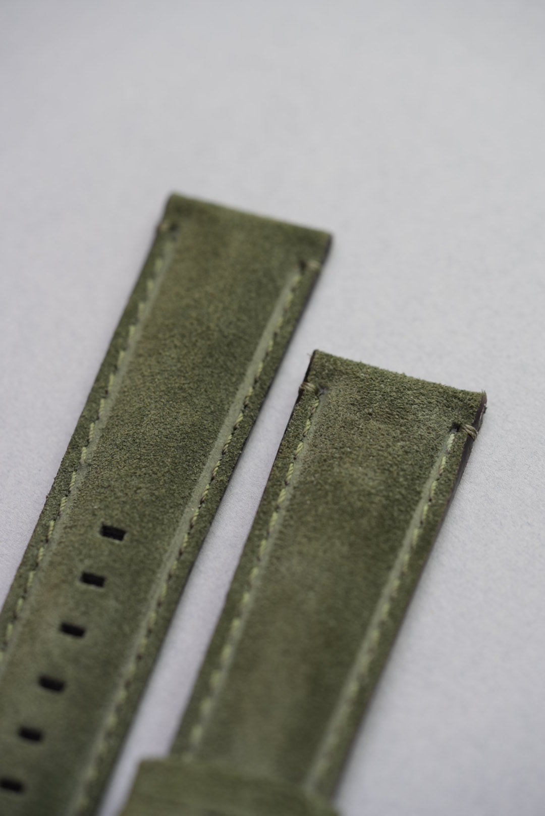 Macro close-up of suede grain and edge finish on green leather watch strap for standard spring bar watches