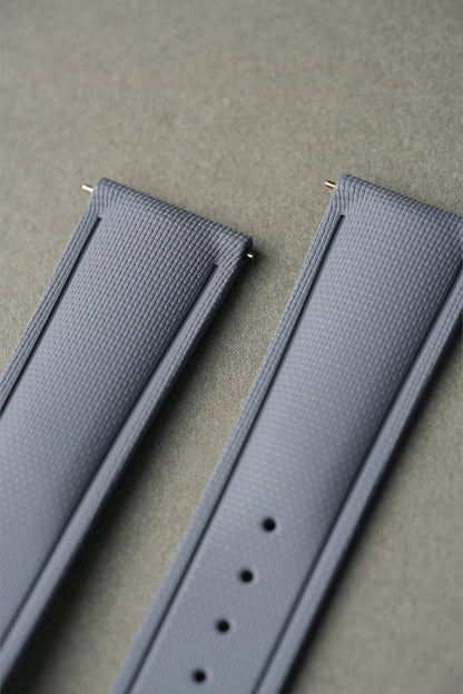 Two gray watch straps on a beige background
