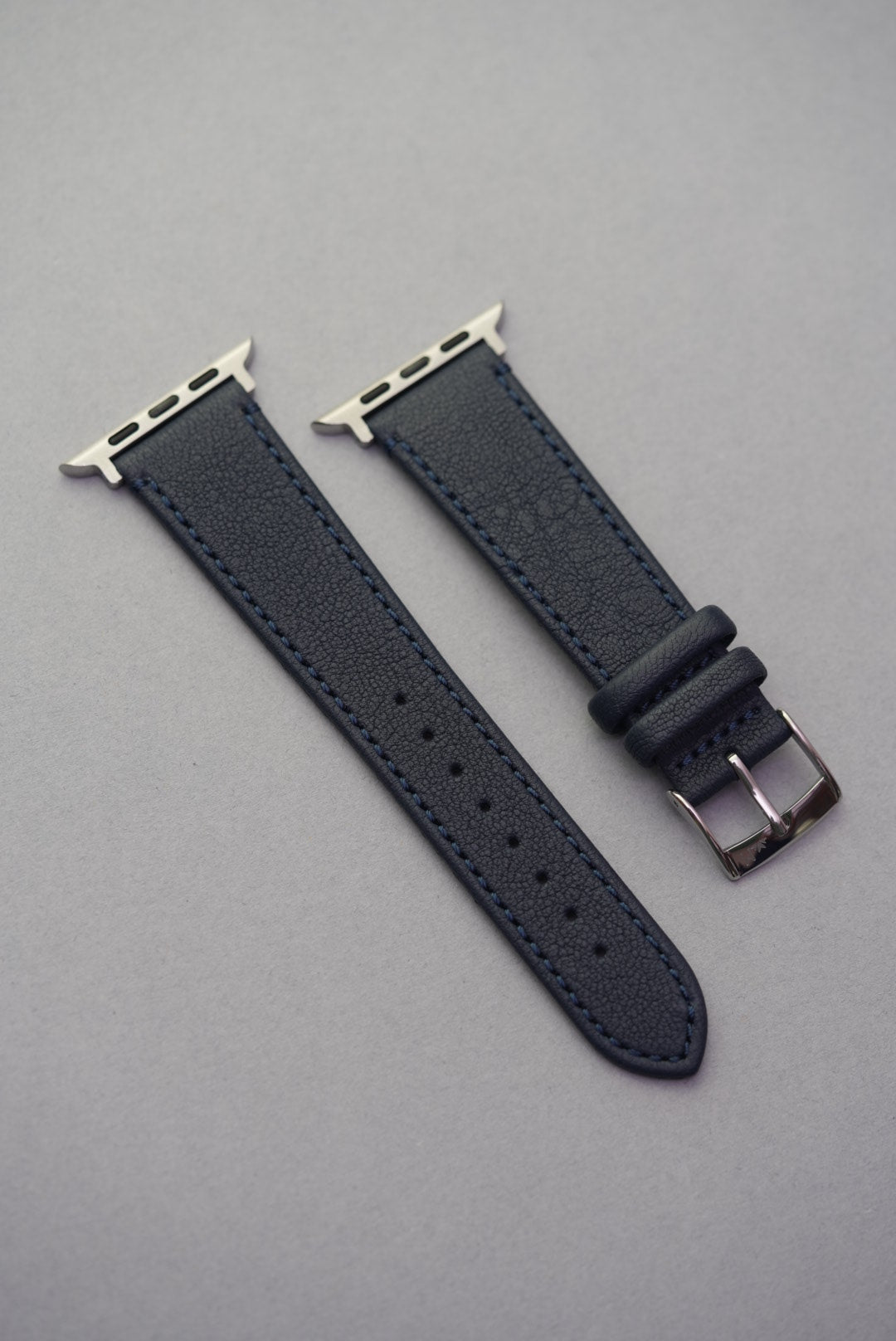 Apple Watch with Midnight Capri strap in soft matte sheepskin leather and matching blue stitching, shown full length.