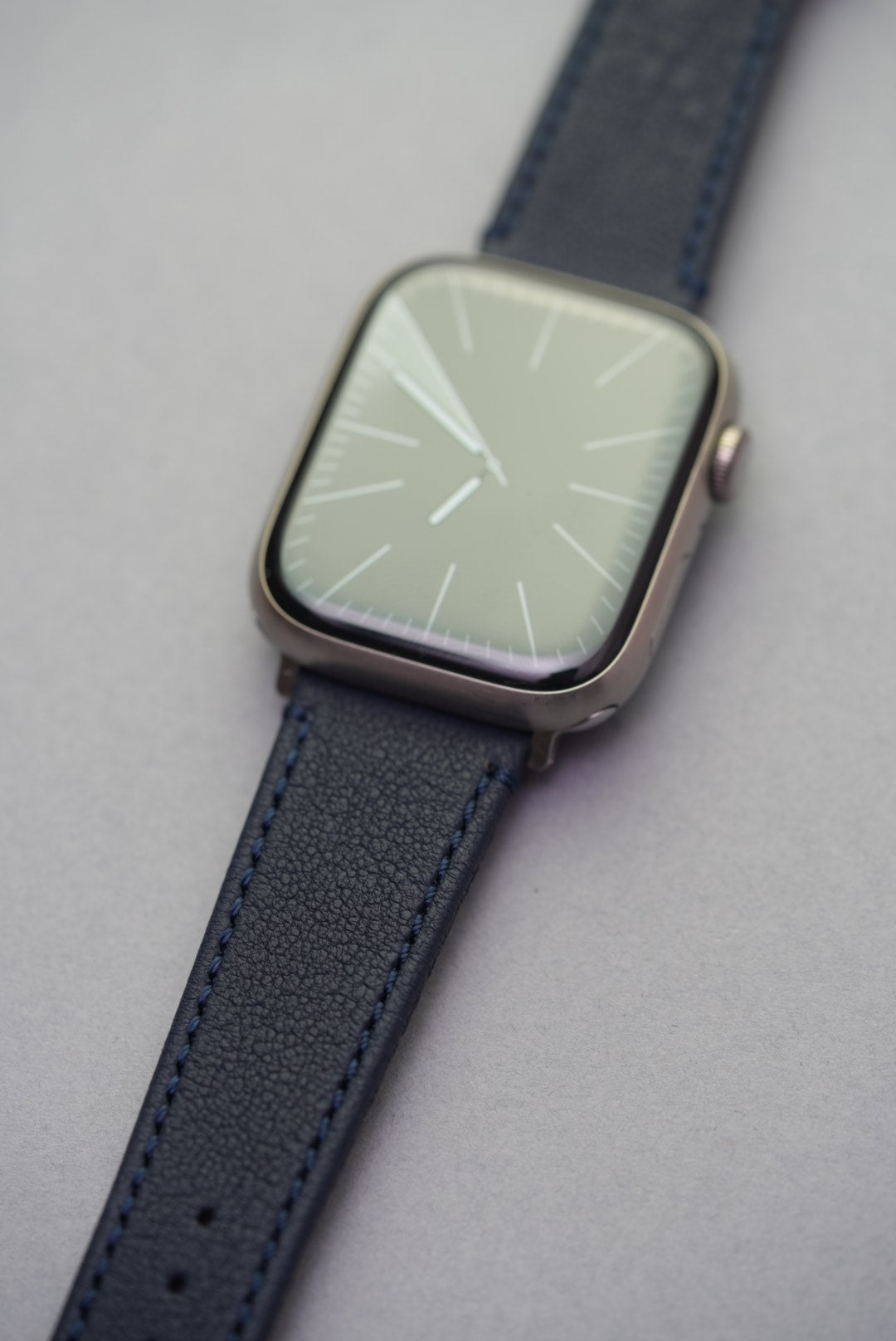 Flat lay of Midnight Capri Apple Watch strap showing both buckle and adapter ends in stainless steel.

