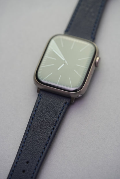 Flat lay of Midnight Capri Apple Watch strap showing both buckle and adapter ends in stainless steel.

