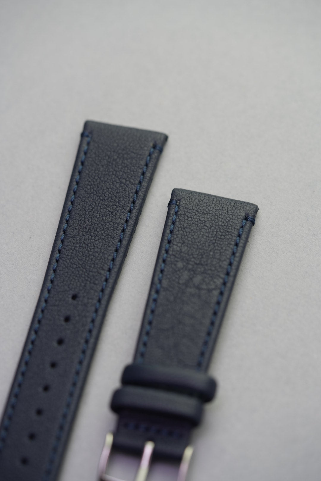 Close-up of Midnight Capri sheepskin strap buckle, highlighting stitching and grain texture.