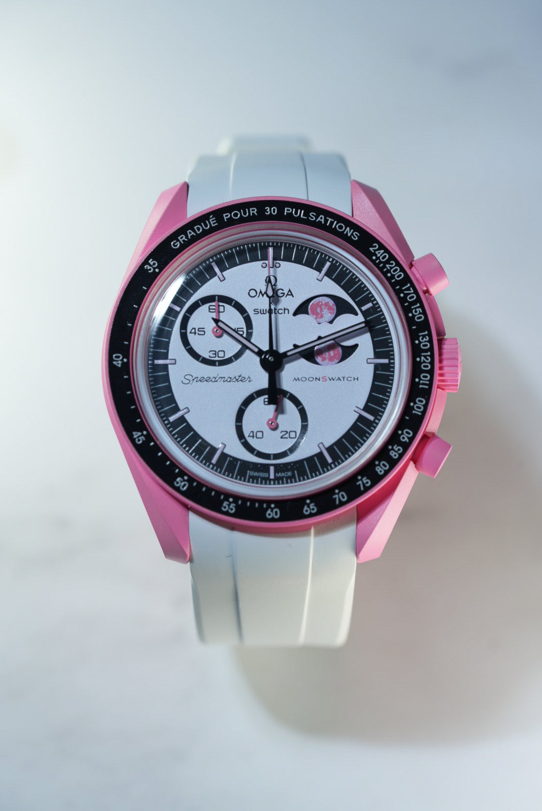 Front-facing shot of the Mission to Pink Moonphase MoonSwatch with white strap – highlighting the moonphase subdial and chronograph layout.