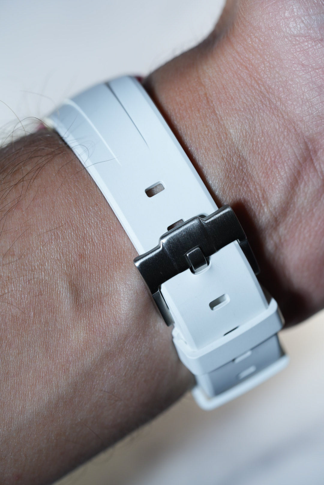 Close-up of the white rubber strap and stainless steel buckle on the Swatch x Omega MoonSwatch Mission to Pink Moonphase.