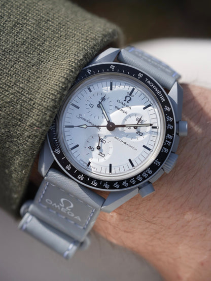 MoonSwatch 1965 dial close-up — black dial with red chronograph accents and tachymeter bezel