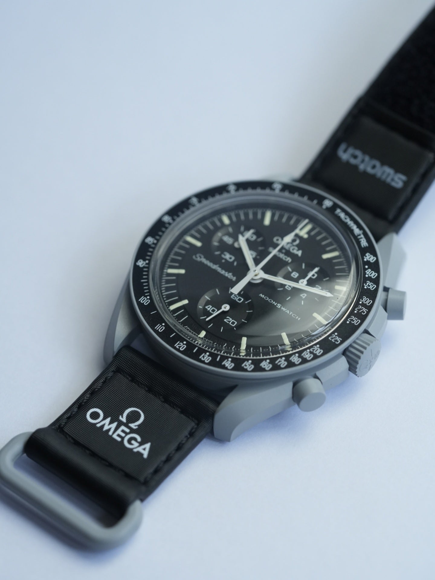 MoonSwatch Mission to the Moon — side profile showing grey Bioceramic case and black velcro strap