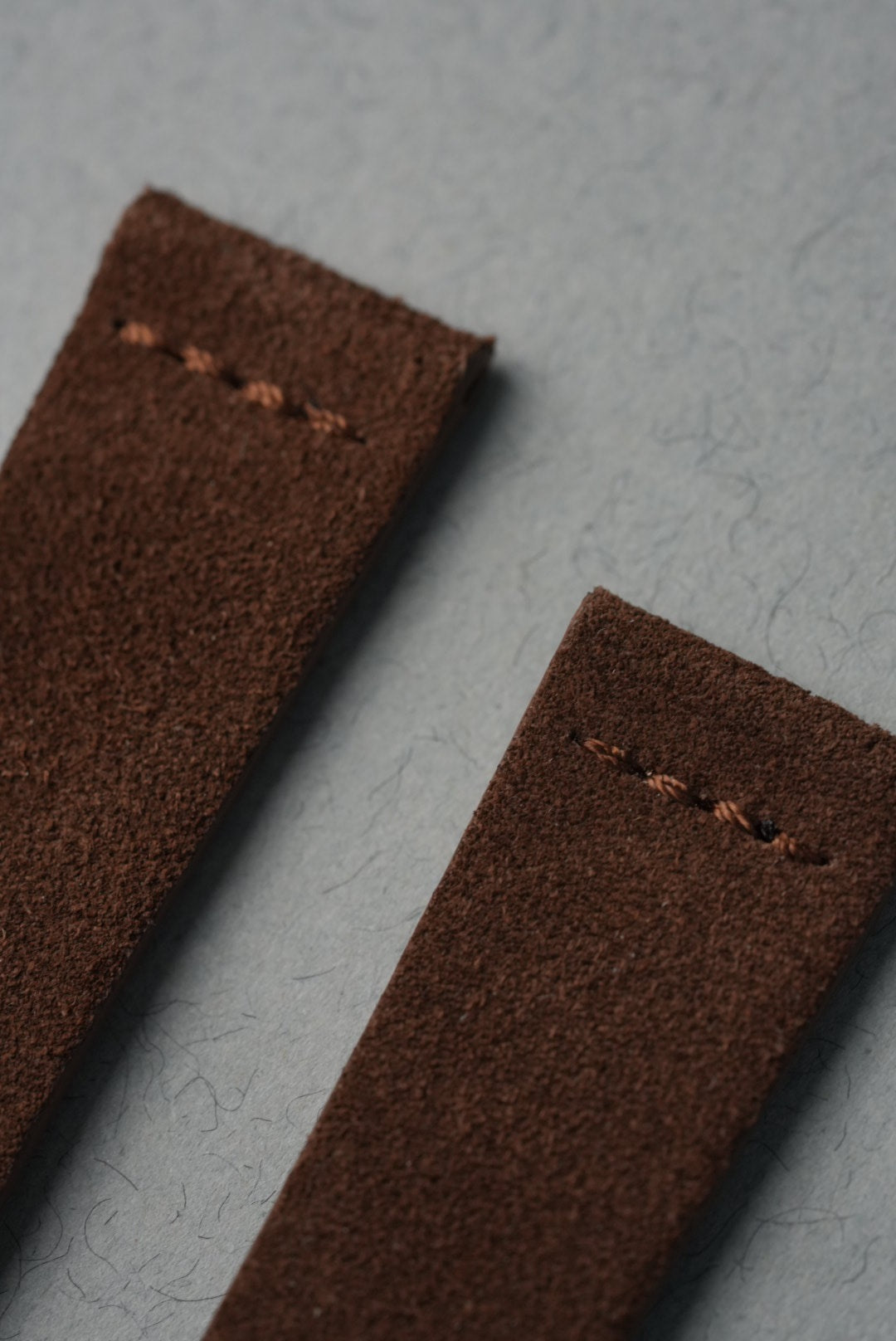 MoonSwatch Saturn with brown suede strap — angled view showing strap-to-case fit at lugs