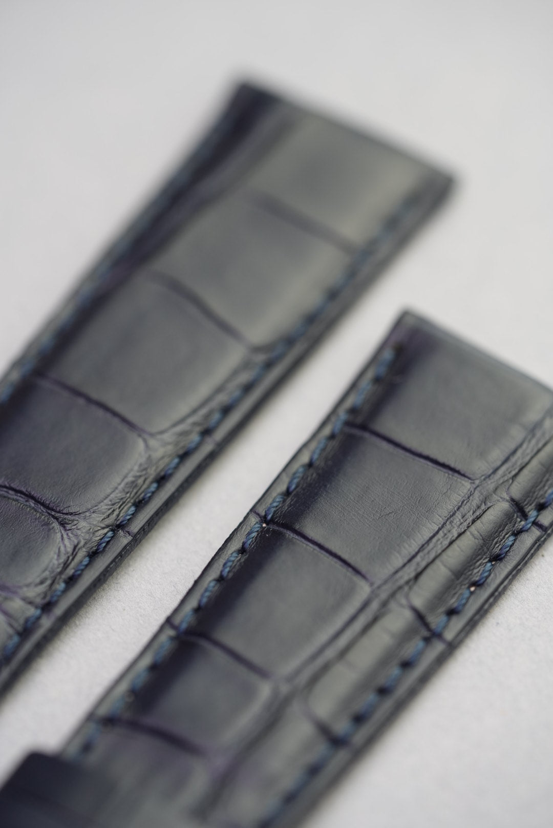 Close-up of blue stitching and grain on navy alligator embossed leather watch strap