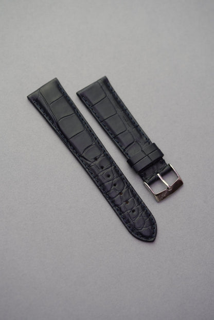 Navy blue alligator embossed leather watch strap laid flat with polished buckle – ideal for strap replacement