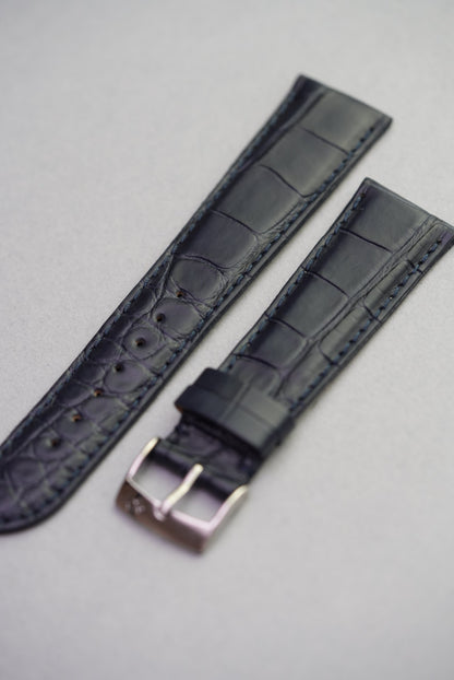Angled front view of navy alligator grain strap showing full texture and stitching