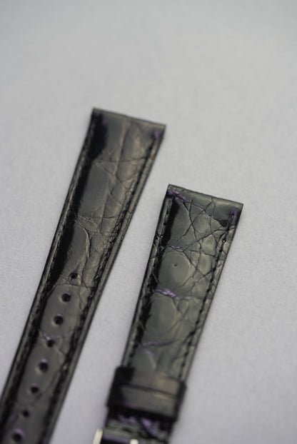 Noir crocodile strap for Cartier laid flat, with even stitching and a natural high-sheen scale pattern across the surface.
