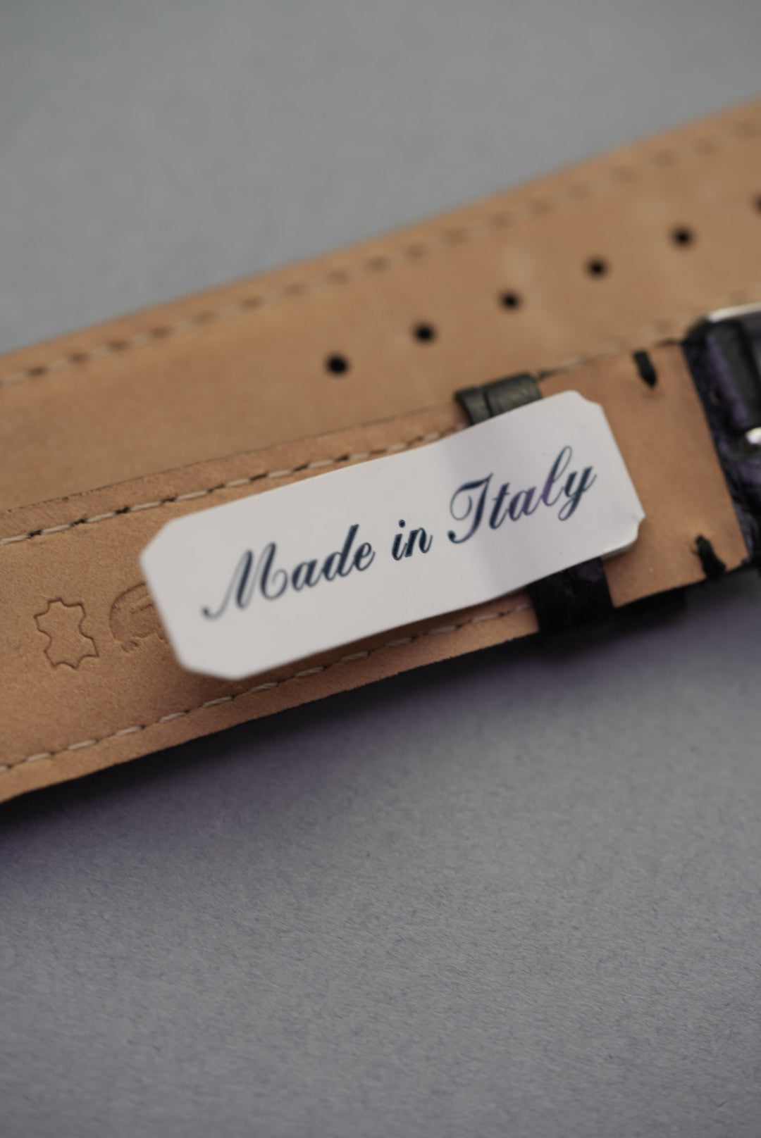 Underside of the Noir crocodile leather strap for Cartier, marked "Made in Italy" with soft tan lining and stitched edges.