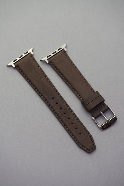 Brown nubuck Apple Watch strap shown flat with silver lugs and matching stitching.