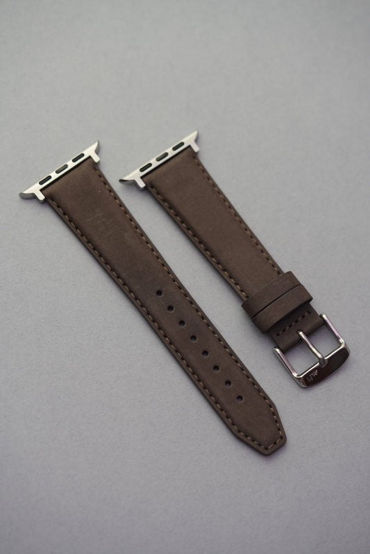 Brown nubuck Apple Watch strap shown flat with silver lugs and matching stitching.