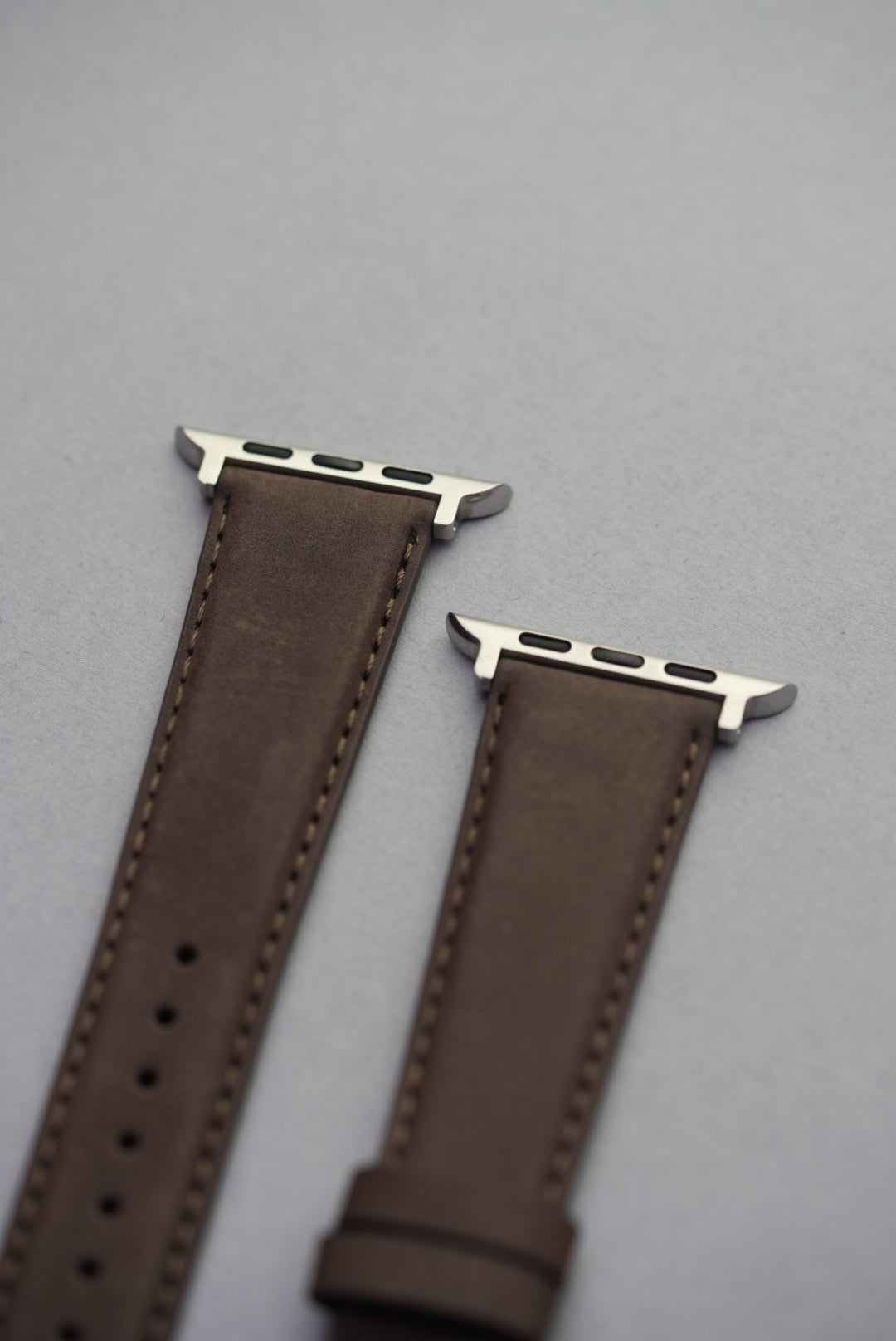  Brown nubuck strap on Apple Watch, showing matte texture and precision stitching.